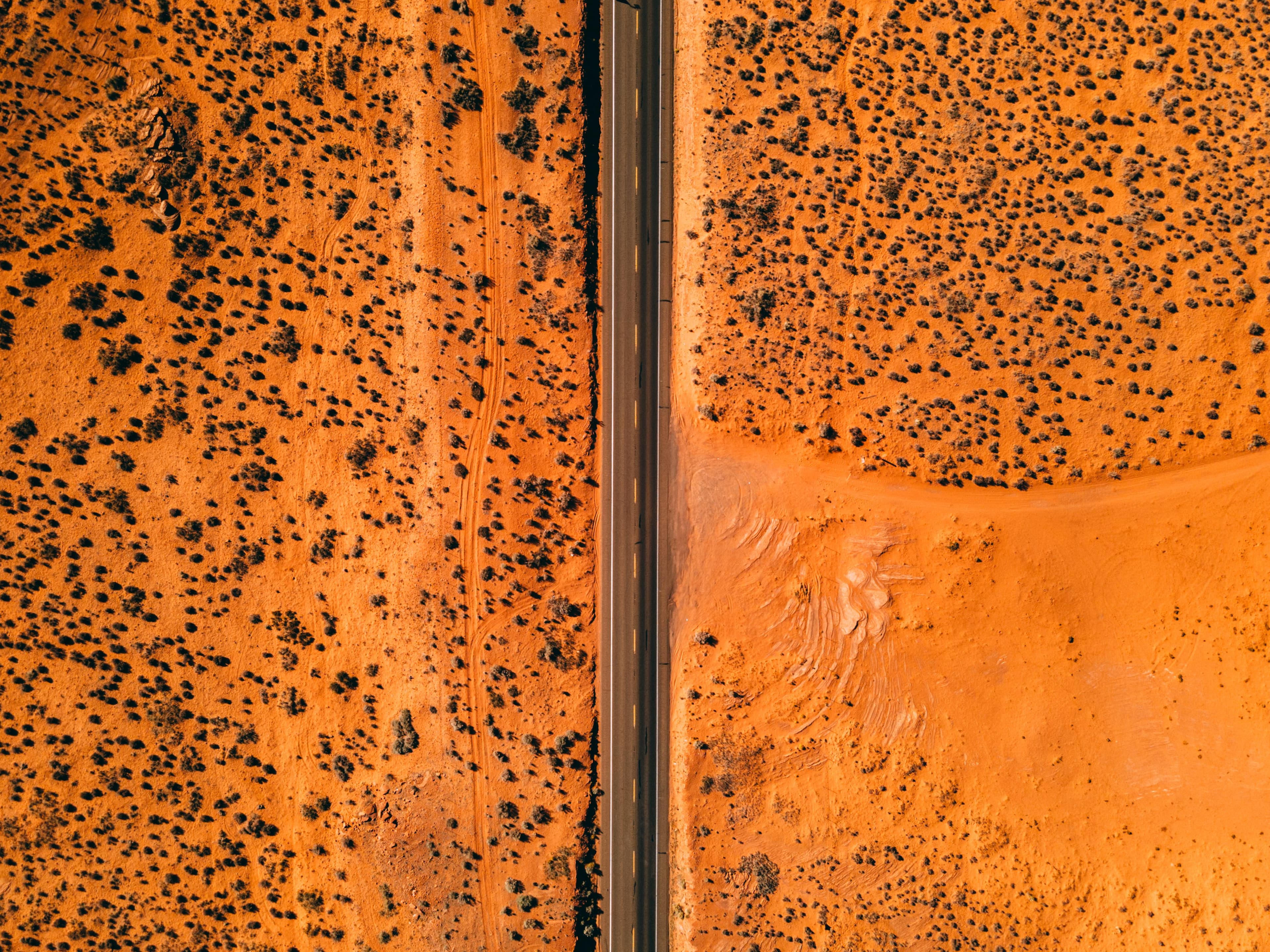 Aerial photograph of a paved road through open desert land.