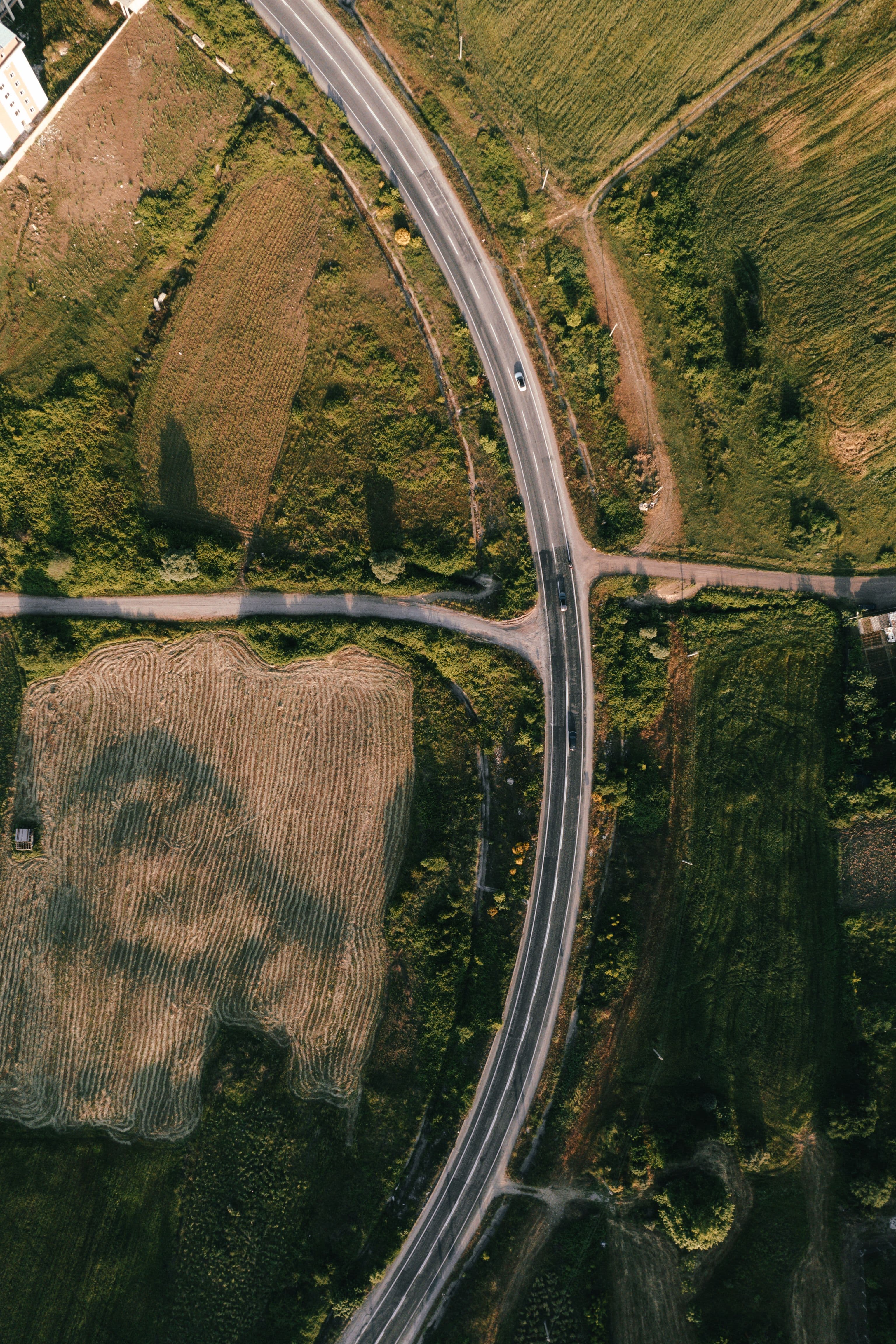 Aerial curving roadway between fields