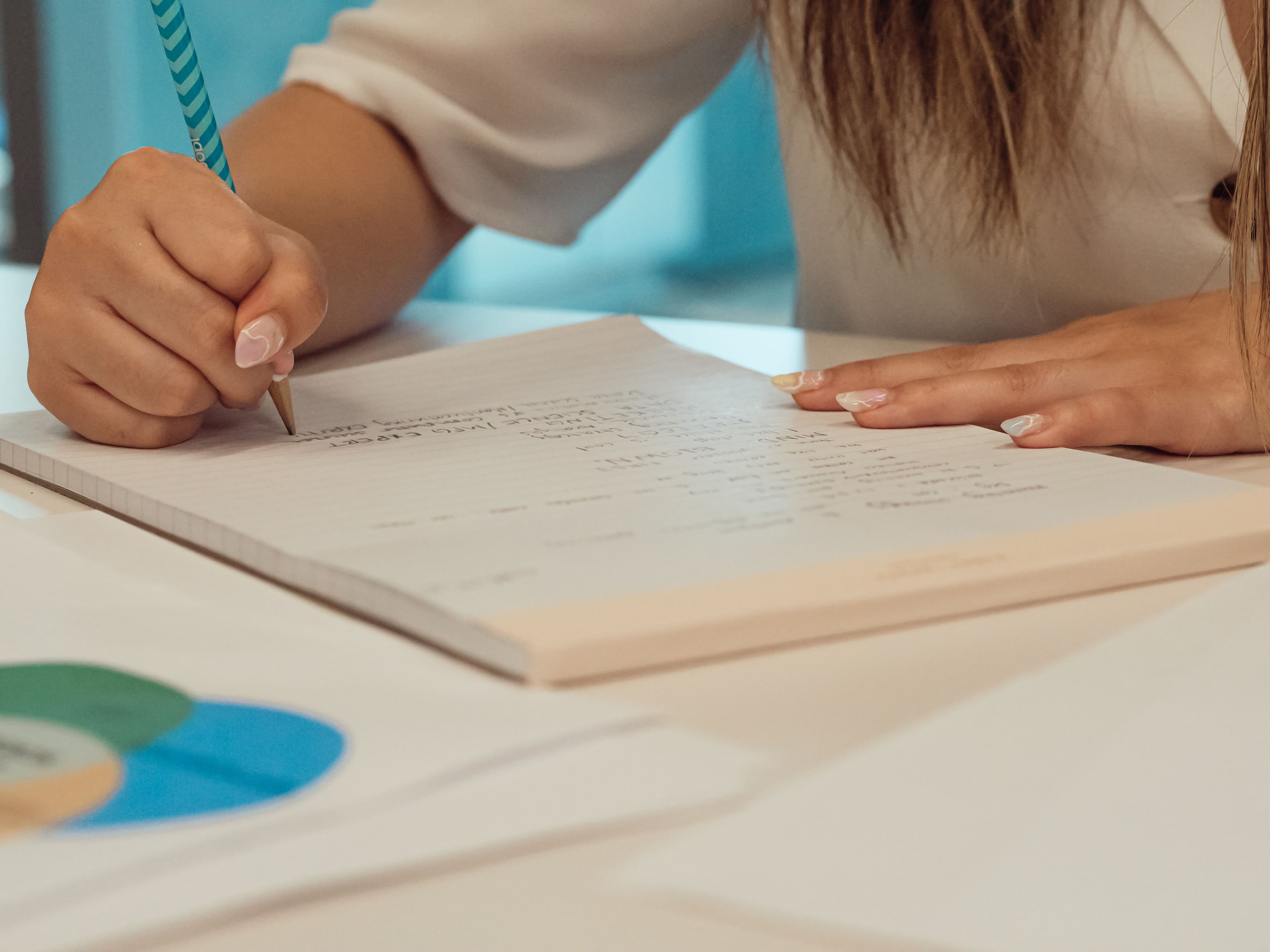 Hand taking notes on a document at a desk